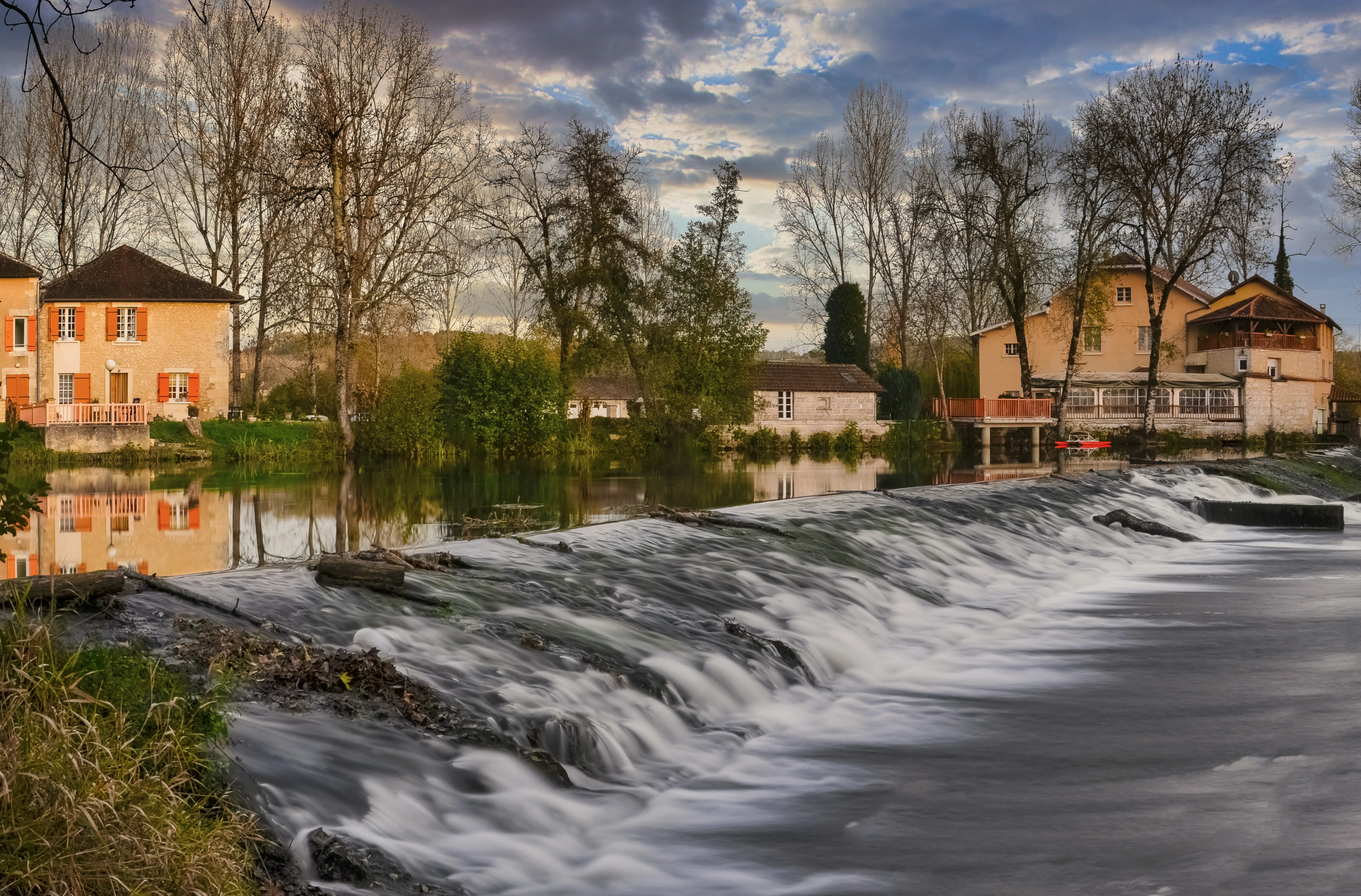 Photo: Houses and trees in the background. Flooding in the foreground.