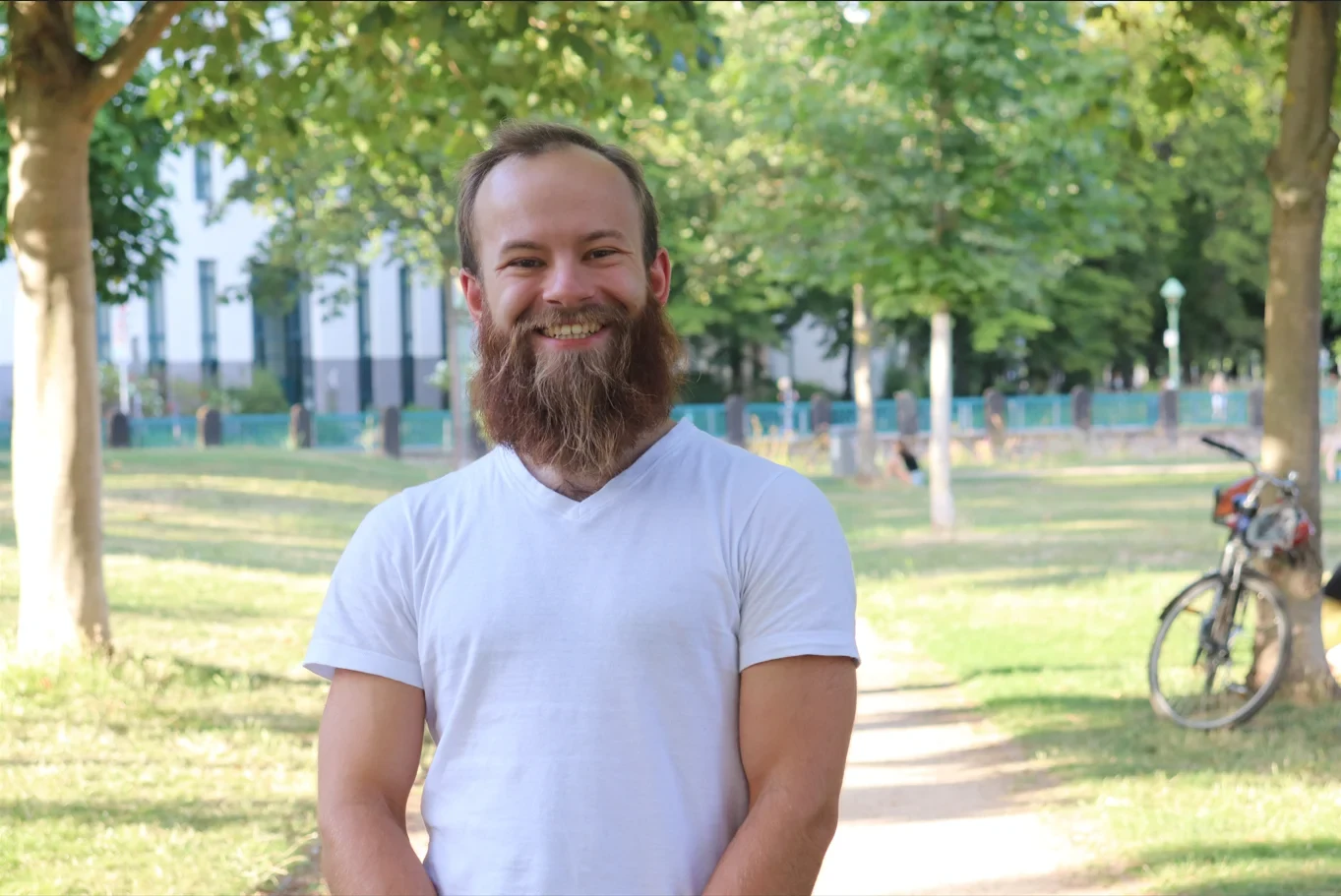 Eine Wissenschaftlerin und ein Wissenschaftler arbeiten hinter einer Glasfassade und mischen Chemikalien mit Großgeräten.